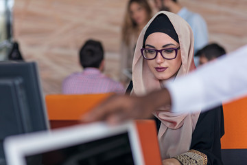 Attractive Muslim young woman working in office on computer