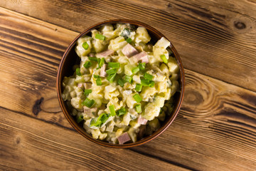 Traditional Russian festive salad Olivier on wooden table