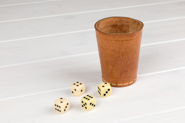 dice cup with cube wooden background