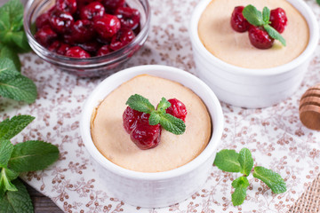 Dessert with cherry in a glass jars on wooden background