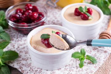 Dessert with cherry in a glass jars on wooden background