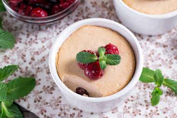 Dessert with cherry in a glass jars on wooden background