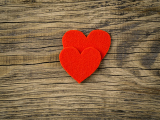 two bright red hearts on dark vintage texture old wood background, symbol of Valentine's day, copy space for text, top view.