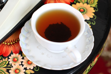 Black tea in a white cup on the table