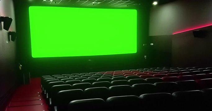 cinema interior of movie theatre with empty red seats with copyspace on the chroma key green screen and glow on edge, concept of recreation and entertainment