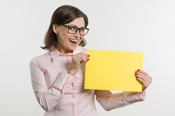 Naklejka premium Smiling middle aged woman with yellow sheet of paper