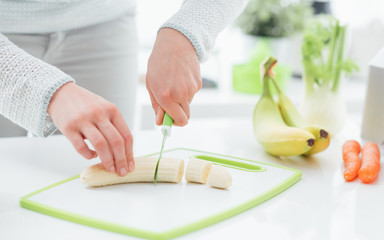 Woman slicing a banana
