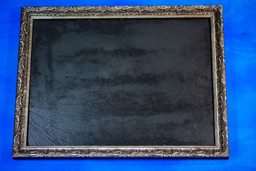 Schiefertafel im Rahmen, blauer Hintergrund