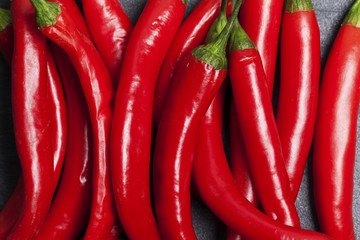 Red fresh chili peppers on a dark slate background