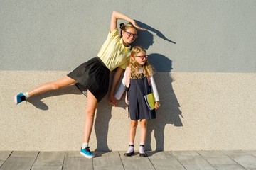 A high school student and an elementary school student are posing for a camera.