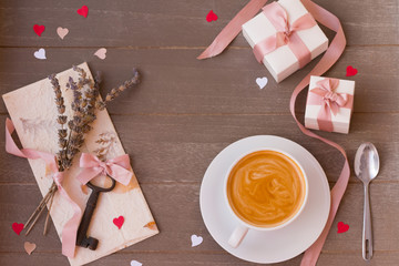 Frame of gifts, key, love letter and hearts on wooden background. Valentine's day.