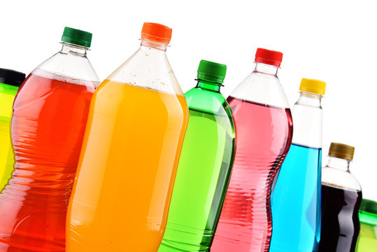 Plastic bottles of assorted carbonated soft drinks over white