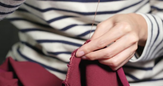 Sews with a needle and thread by hand