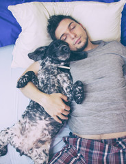 Hombre joven durmiendo con su perro 