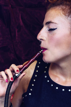 Mujer joven fumando en cachimba