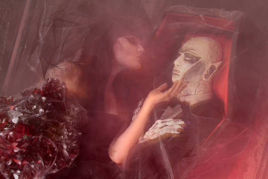 beautiful witch performs a ritual with the coffin with the dead doll men