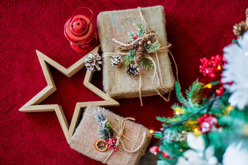 Decorative Christmas present, red flashlight and wood star under the Christmas tree. Close up. Concept marry Christmas. Postcard. Flat lay