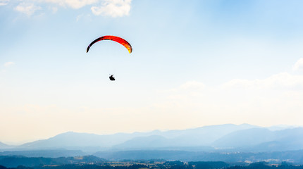 Paraglider is flying in the valley.