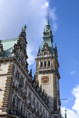 Fototapeta na wymiar Germany, Hamburg: Detail of famous city hall - Hamburg Rathaus - in the city center with tower clock and blue sky in the background.