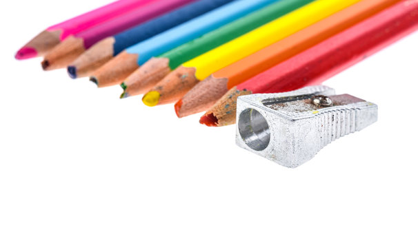 Set of old used broken colour pencils and metal sharpener.