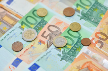 Euro coins over paper euro banknotes. Euro money banknote, business and finance concept