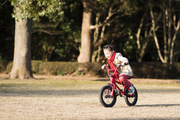 赤い自転車に乗る女の子