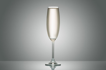 one transparent glass with calm champagne on grey