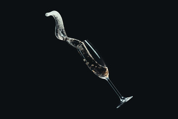 spilling champagne from falling glass isolated on black