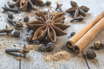 Cinnamon, cloves and star anise on a wooden table.