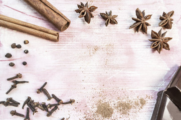 Star anise, chocolate, cinnamon and cloves on wooden table.