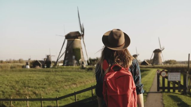 Young businesswoman feeling happy near a windmill. Successful female entrepreneur enjoys rustic mill farm scenery. 4K.