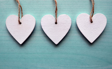 Decorative white wooden hearts on a blue wooden background with copy space.Valentine's Day,Mother's Day holidays concept.