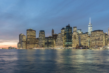 Naklejka na ściany i meble Manhattan's Financial district skyline at night from the Brooklyn Bridge Park, New York City