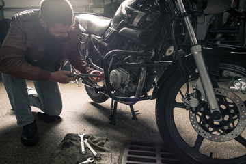 Fototapeta na wymiar Young bearded man fixing bike
