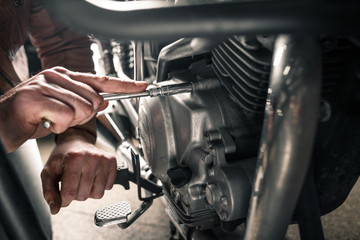 Close up of man's hand fixing motorcycle