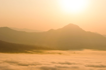Early morning foggy sunrise on top of mountain soft focus.