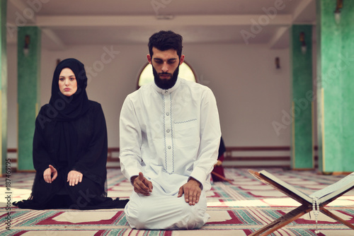 Muslim Man And Woman Praying In Mosque
