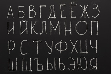 Fototapeta na wymiar Cyrillic alphabet on black chalkboard
