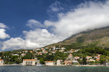 Fototapeta na wymiar The town of Mlini in Croatia with clouds in the background.