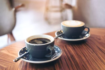  Closeup image of two blue cups of hot latte coffee and Americano coffee on vintage wooden table in cafe © Farknot Architect