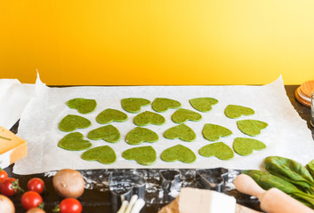 Chef cook step by step makes green ravioli in the shape of a heart for a festive dinner