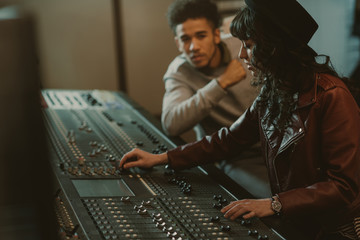 sound producers working with graphic equalizer at recording studio