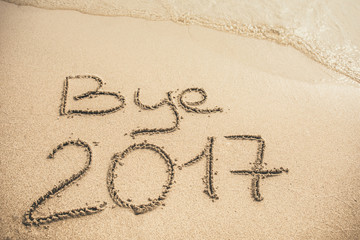 Bye 2017 text written on the sand