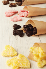 Lovers day background with various sweets in craft cornets