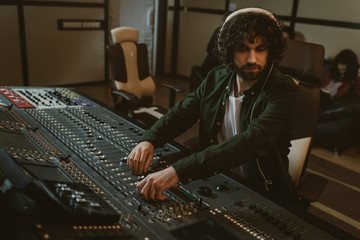 focused young sound producer working at studio