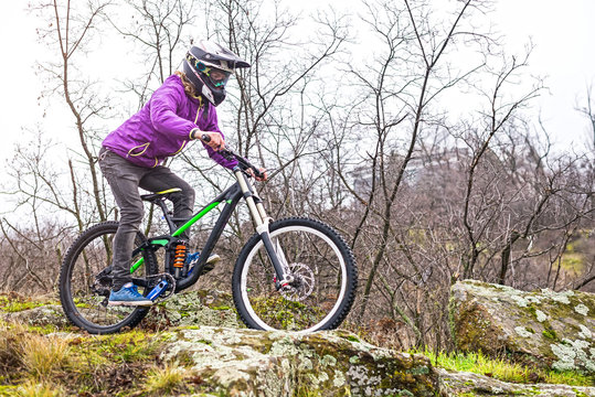 Professional Cyclist Riding the Mountain Bike on the Rocky Trail, copy of free space.