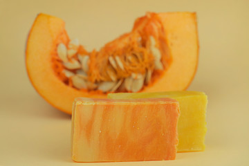 pumpkin soap. orange soap with pumpkin extract and a piece of fresh pumpkin on yellow background. Organic Natural Cosmetics for the Body