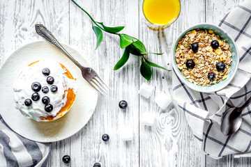 Breakfast concept with flowers on wooden background top view