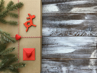 Winter flat lay with romantic decorations: gift box with red heart and fir branches on vintage wooden background. Valentines day composition, top view. Love or congratulation concept. 