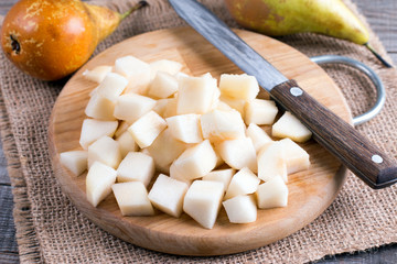 Fototapeta na wymiar Cubes of pears on a cutting board on a table